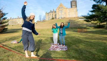 Students slackline on Libe Slope on a warm winter day.