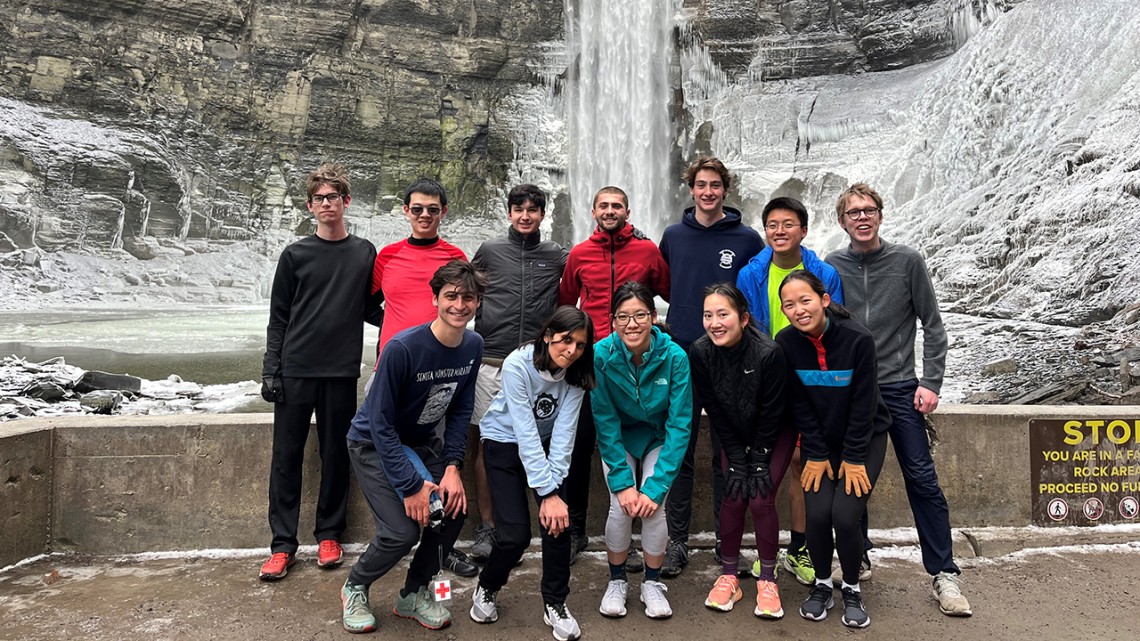 Joanne Wang poses in front of Taughannock Falls with members of Cornell Running Club